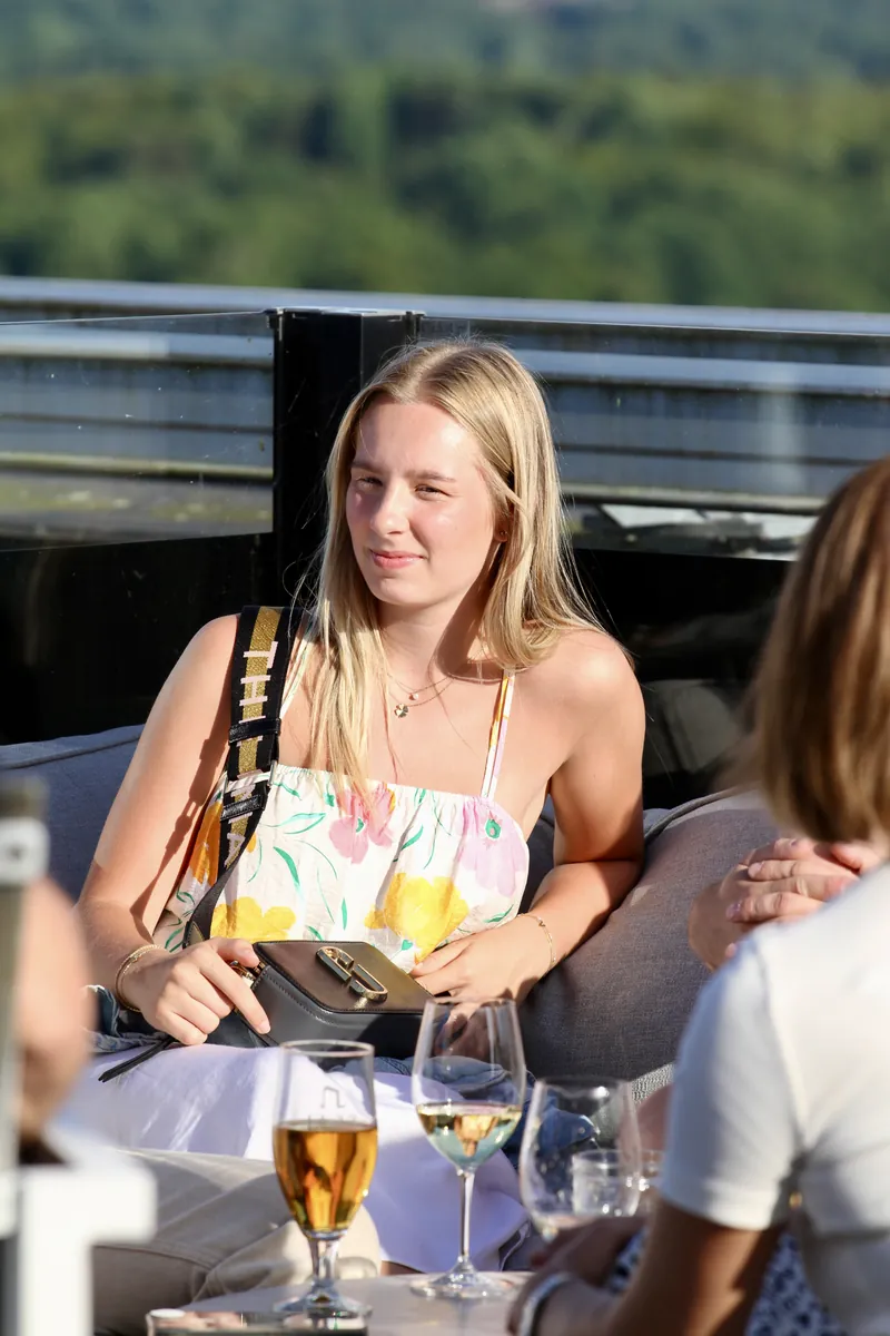 Gäst med ett glas i handen på terrassen