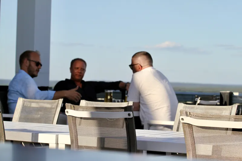 Tre gäster vid ett bord på terrassen med utsikt
