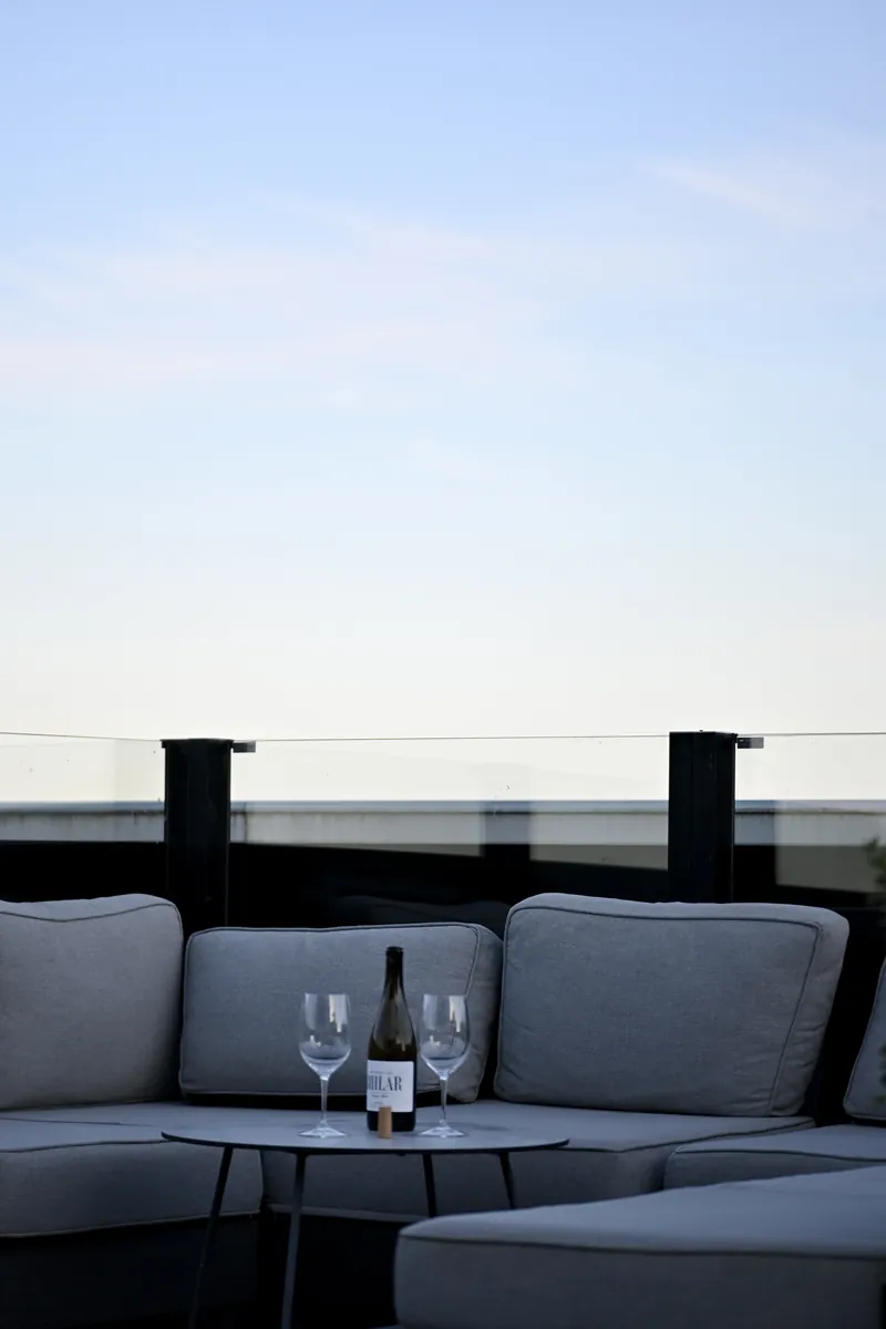 Loungen på terrassen i skymningen, två glas och en flaska på bordet