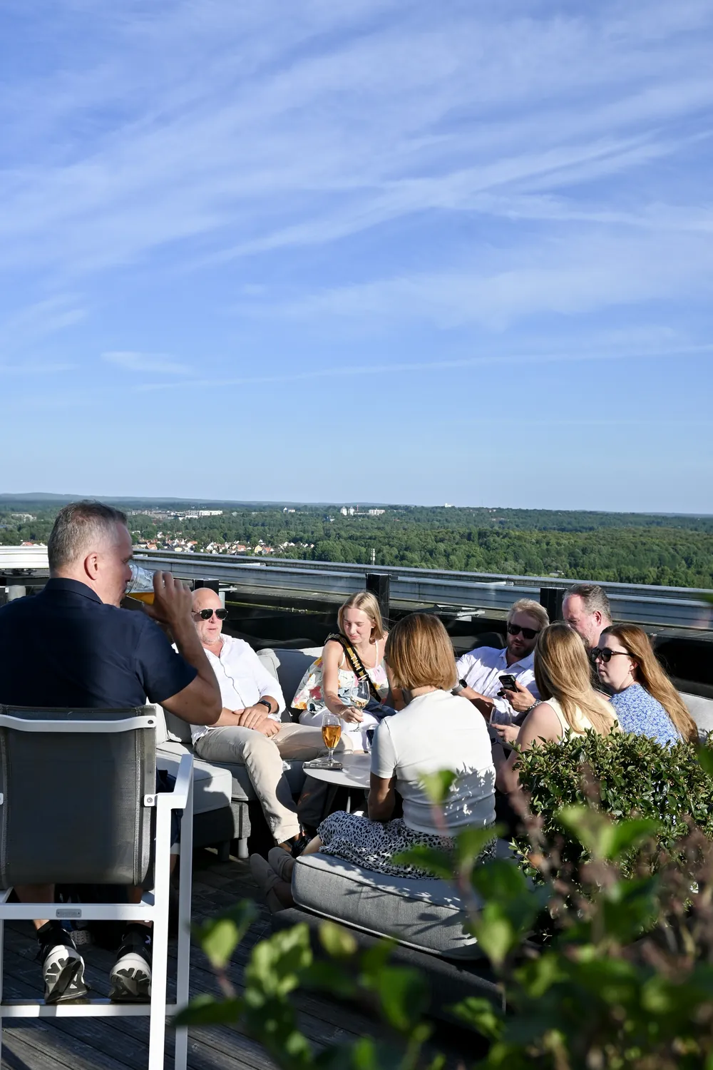 Gäster på terrassen på våning 19 i kvällssol, med utsikt över Växjö