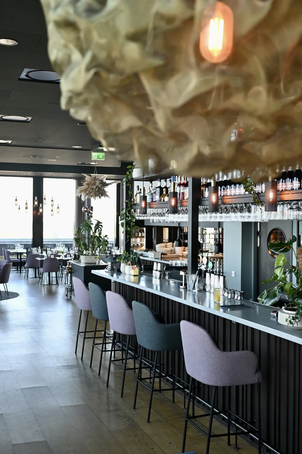 Baren och matsalen på SKAI utan gäster, lamporna tända och fönstren mot staden