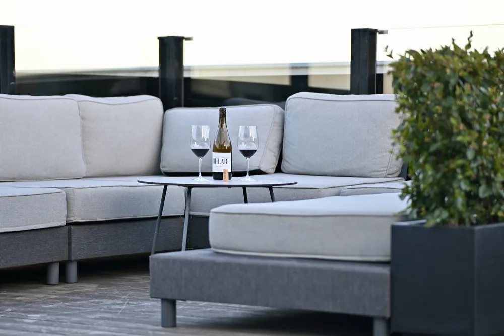 Terrassloungen på våning 19 i skymningen, soffor och vin på bordet